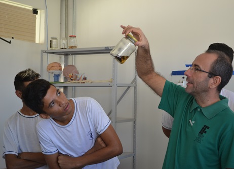 Visitantes acompanham explicações no laboratório de biologia