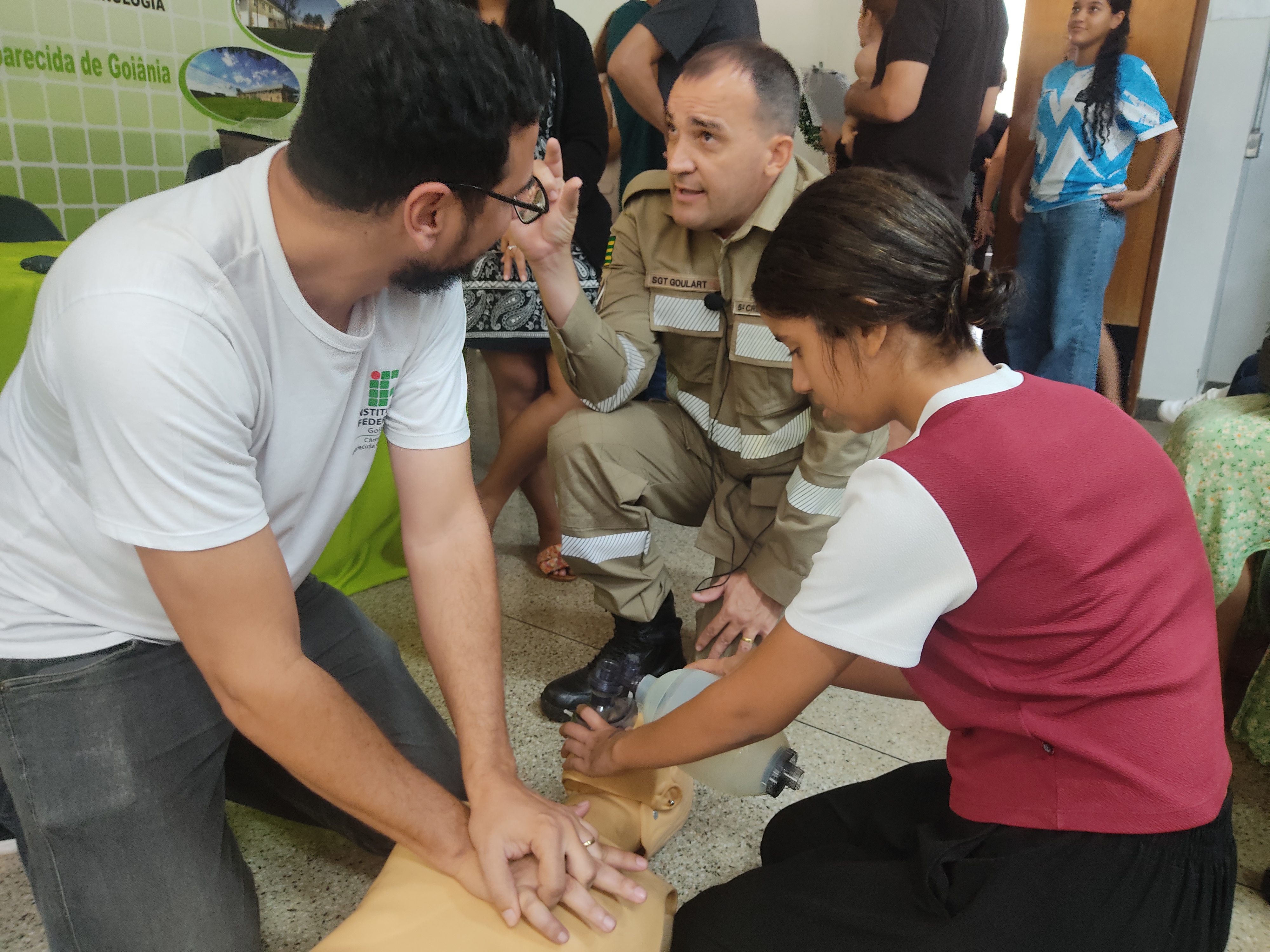 Sargento Clésio Borges de Sousa Goulart, do Corpo de Bombeiros de Goiás, orientando servidores e estudantes no atendimento a uma vítima de parada cardiorespiratória enquanto aguardam, em simulação, o atendimento médico ou do Corpo de Bombeiros