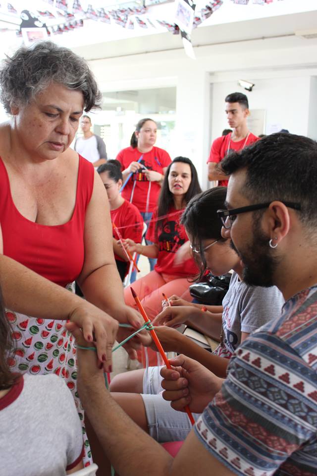 Oficineira da oficina de maxi tricô orientando os alunos